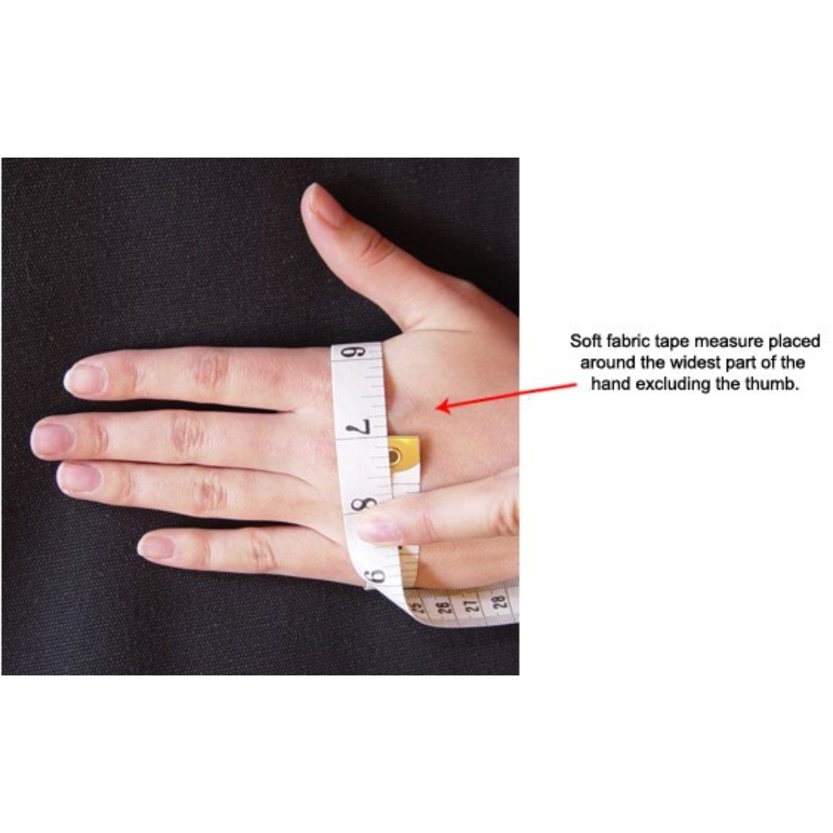 Hand with a soft fabric tape measure around the widest part of the hand excluding the thumb on a black background.