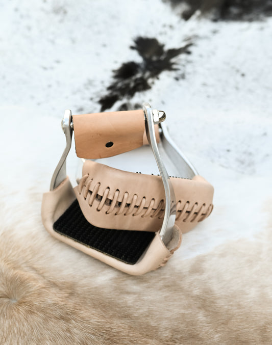 AJ Tack Twisted Slant Stirrups on a cowhide rug