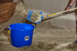 Horse owner scooping muck into a muck bucket