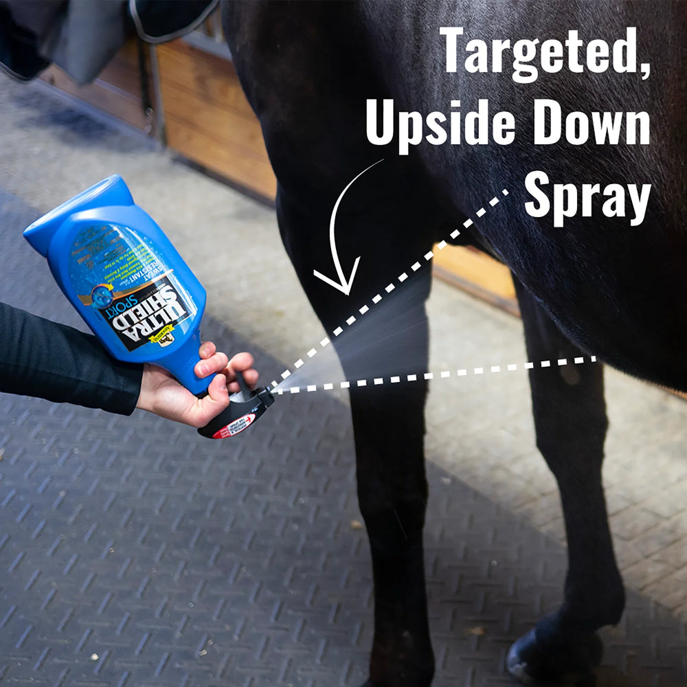 horseowner spraying the UltraShield Sport Insecticide and Repellent spray with the bottle held upside dow to show that the bottle can still function while behind held upsidedown