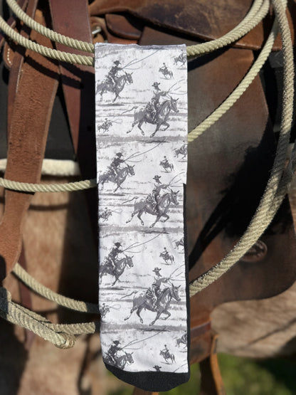 Sock with cowboy and horse pattern on a background of a saddle and reins